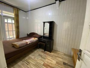 Un dormitorio con una cama, una cómoda y un espejo. en Homestay Ulya 1, en Banjarnegara