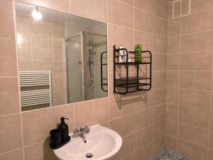 4 pers studio style room Near South Wimledon station R3 في لندن: حمام مزود بحوض ومِرآة
