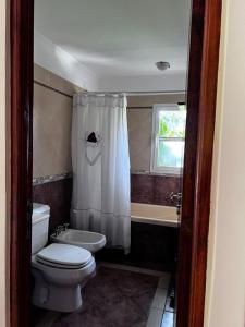 a bathroom with a toilet and a sink and a tub at CHALET GRANDE en VALERIA DEL MAR y PLAYA in Valeria del Mar +25 photos