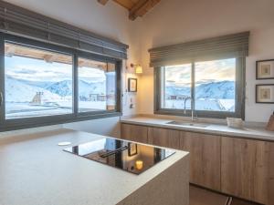 a kitchen with a sink and two large windows at Chalet d'exception, ski-in/ski-out, sauna et jacuzzi, Alpe d'Huez - FR-1-645-81 in LʼHuez +8 photos