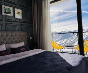 a bedroom with a bed and a balcony with a view at Twins apartment deluxe, new gudauri in Gudauri +20 photos