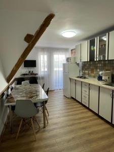 a kitchen with a table and a dining room at Casa Sofia Dorna Candrenilor in Dorna Cîndrenilor