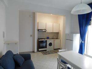 a living room with a blue couch and a kitchen at Appartamento presso Residence Erice Beach - Casa Vacanza in Erice