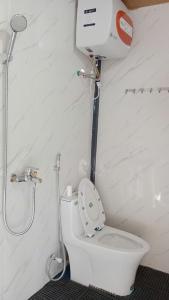 La salle de bains est pourvue d'une douche et de toilettes avec siège de toilette. dans l'établissement Homestay phố núi suối giàng, à Yên Bái