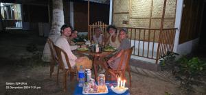 a group of people sitting at a table with food at Jungle Beach Resort in Neil Island +18 photos