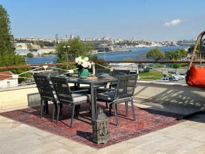 een tafel en stoelen op een balkon met uitzicht op een rivier bij Waterfront Apartment by the Tram - Terrace with Dome & Golden Horn View in Fatih in Istanbul +134 foto's