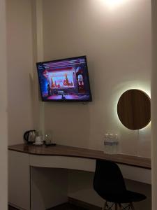 una TV a schermo piatto a parete con scrivania di Hong Nhan Hotel a Da Lat