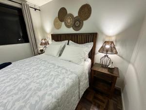 a bedroom with a bed and two lamps on a table at Barra Velha - Itajuba Beach House in Itajubá