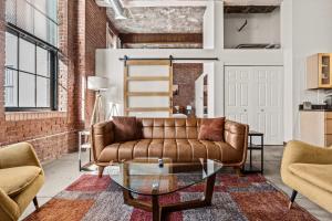 a living room with a couch and a glass table at Luxury Industrial 2 Bedroom 2 Full Bath Strip District & Riverwalk in Pittsburgh