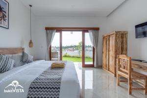 a bedroom with a large bed and a window at Agra Villa Bali by Bukit Vista in Uluwatu