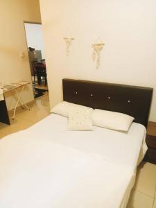 a white bed with two pillows on top of it at Palas Horizon Cameron Highland in Brinchang +5 photos