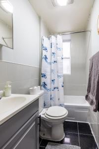 a bathroom with a toilet and a sink and a shower at Inspire the Vibrant Energy of the UWS in New York
