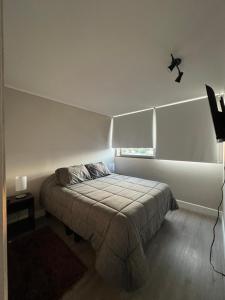 a bedroom with a bed in a white room at Moderno y cómodo departamento in Coquimbo