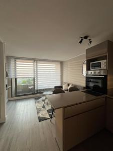 a living room with a couch and a kitchen at Moderno y cómodo departamento in Coquimbo +6 photos