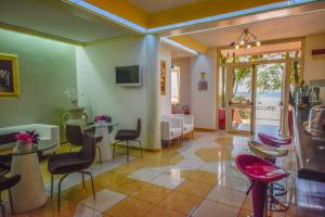 eine Lobby mit Tischen und Stühlen und ein Wohnzimmer in der Unterkunft Hotel La Villa in Corigliano Calabro