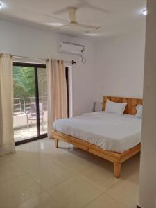 a bedroom with a bed and a large window at hotel ramdev in Arambol +19 photos