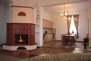 a living room with a fireplace and a dining room at Pensiune AgroTuristica Horváth-Kert in Borzont