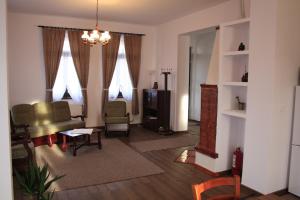 a living room with a couch and chairs and windows at Pensiune AgroTuristica Horváth-Kert in Borzont