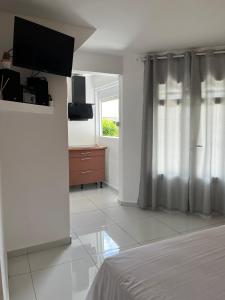 a bedroom with a bed and a dresser and a window at Domaine De Marly, 3 étoiles in Sainte-Anne
