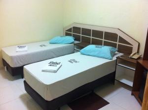two beds in a small room with a telephone at Hotel Praça Orione in São Paulo