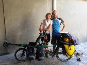 a man and a woman standing next to a bike at Rumi Hotel & Hostel in Bukhara