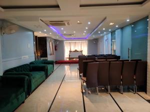 a conference room with green chairs and a table at Geetanjali International in Deoghar