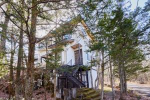 a white house with a staircase in the trees at rinne 2nd living Kitakaruizawa Forest in Tsumagoi