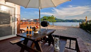 a picnic table on a deck with an umbrella at Ganghwa Granblue Pension in Incheon +9 photos