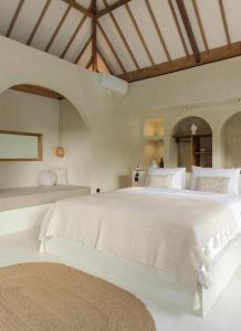 a large white bedroom with a large bed at Villa Maja Bingin Boutique Hotel in Uluwatu
