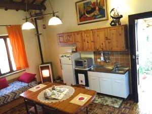a kitchen with a table and a kitchen with a refrigerator at Maison Diamanti in Castel di Lama