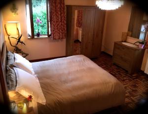 um quarto com uma grande cama branca e uma casa de banho em Maison Diamanti em Castel di Lama