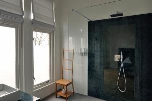 een badkamer met een douche, een wastafel en een douche bij Boetiek Hotel Kampen in Kampen +37 foto's