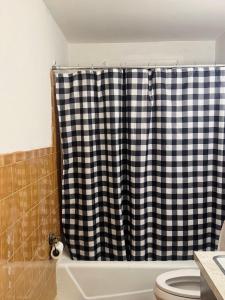 a bathroom with a black and white shower curtain at The Regal Sanctuary in Niagara Falls