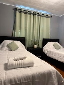 a bedroom with two beds with white sheets at The Regal Sanctuary in Niagara Falls