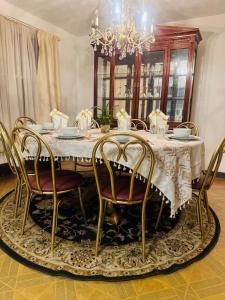 a dining room table with chairs and a chandelier at The Regal Sanctuary in Niagara Falls