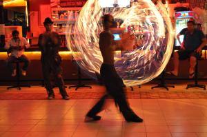 a woman is dancing in a room with a large fire at Club Sunset Apartments in Marmaris +40 photos