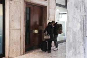 dos personas parados fuera de una puerta con su equipaje en Terzopiano, en Treviso