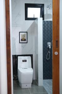 Un baño con inodoro blanco y ventana. en Alisse Stay Phuket Layan, en Phuket
