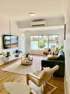 a living room with a couch and a tv at Golden sunset in Glenelg