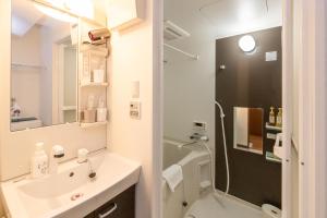 Un baño blanco con lavabo y ducha. en Impulse Imazato, en Osaka
