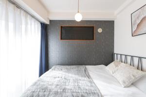 1 dormitorio con 1 cama con pared gris en Impulse Imazato, en Osaka 36 fotos más