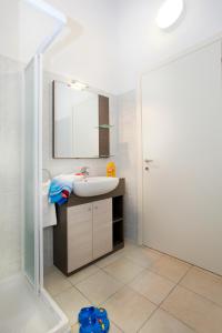 een badkamer met een wastafel, een spiegel en een douche bij Residence Maroadi in Nago-Torbole