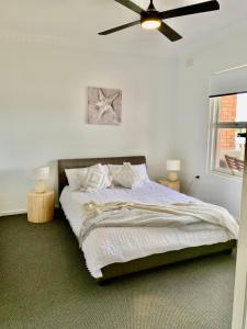 a bedroom with a bed with a ceiling fan at Golden sunset in Glenelg