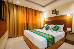 a bedroom with a large bed with yellow curtains at Treebo Anam International in Mumbai +31 photos