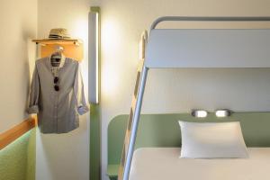 a suit and hat on a hanger next to a bed at Ibis budget Hamburg City Ost in Hamburg