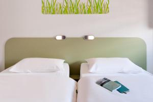 two beds sitting next to each other in a room at Ibis budget Hamburg City Ost in Hamburg