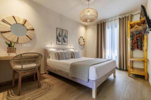 a bedroom with a bed and a chair and a mirror at Limnonari Double room in Skopelos Town