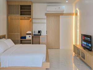 a bedroom with a bed and a flat screen tv at Haadson Resort & Koh Raham in Haad Son