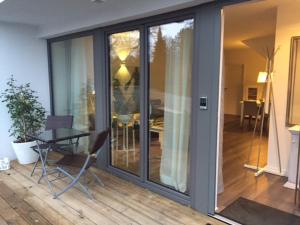a balcony with glass doors and a table and chairs at Ferienapartment am Möhnesee in Möhnesee