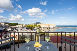 a table with two glasses of wine on a balcony at Sant'Erasmo luxury home in Palermo